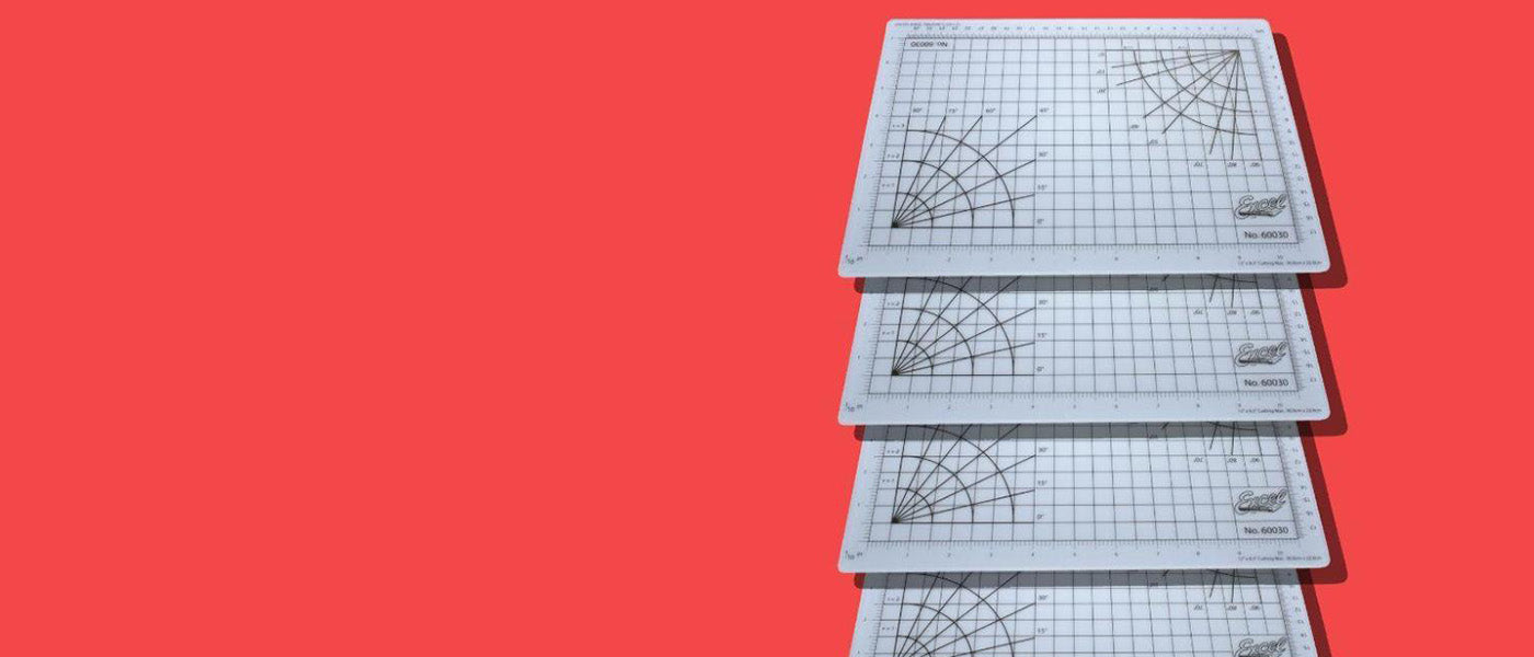 a stack of self healing cutting mats against a red background