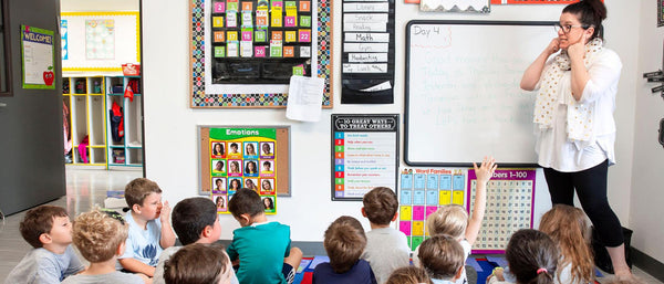 a teacher telling children in a classroom to listen