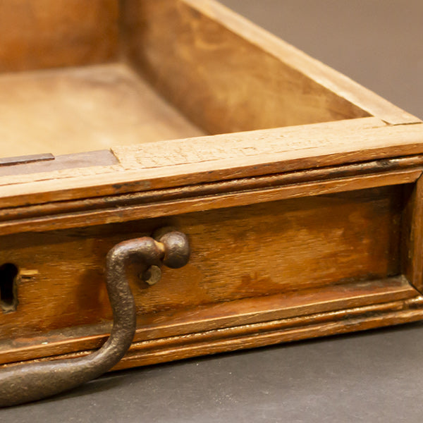 an antique wooden box with a handle