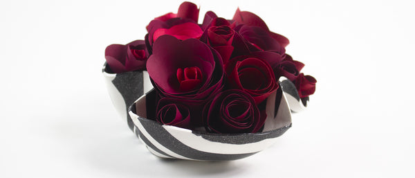 a decorative bowl full of paper roses
